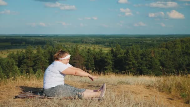 Overweight woman doing physical exercises on nature — Stock Video