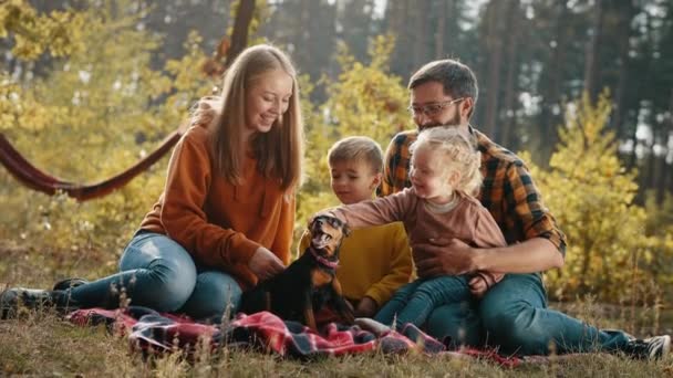 가을 공원에서 자녀가 있는 행복 한 가족 과개와 함께 피크닉을 즐기는 모습 — 비디오