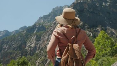 Şapkalı ve sırt çantalı kadın gezgin Aladaglar Milli Parkı 'ndaki Taurus dağlarının tadını çıkarıyor