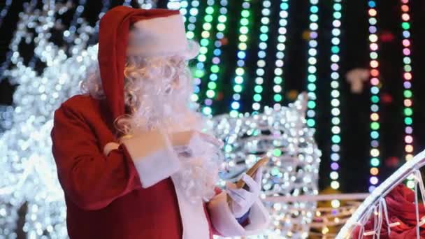 Święty Mikołaj używa smartfona na zewnątrz — Wideo stockowe