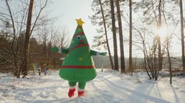 Şişme bebek kostümlü bir adam Noel ağacı sarılmak için koşar.