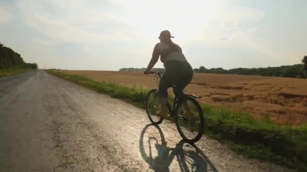 Túlsúlyos fiatal nő veszít súlyfelesleget kerékpározás közben — Stock videók