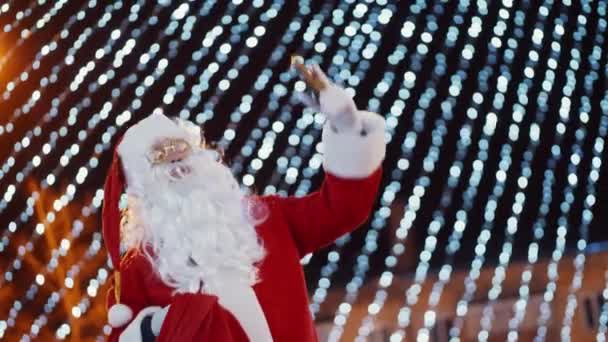 Um homem vestido com um traje festivo tradicional de Papai Noel está dançando alegremente — Vídeo de Stock