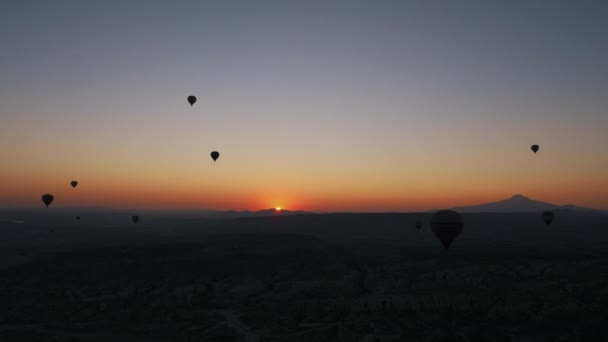 Muitos balões de ar quente voam no céu ao nascer do sol. — Vídeo de Stock