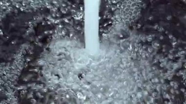 Güçlü su akışının yavaş videosu daha fazla miktarda suya düşer ve hava kabarcıkları oluşturur.