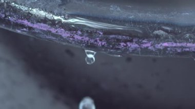 Bir kenardan düşen su damlasının yavaş çekim videosu