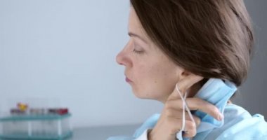 Uzun ve yorucu bir vardiyadan sonra çok yorgun görünen bir doktor, koruyucu giysileriyle konuşuyor.