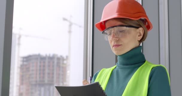 Portret Pracującej Budowniczki Kasku Piszącej Notatki Notatniku Kobieta Inżynier Tle — Wideo stockowe
