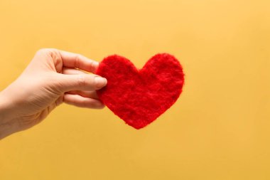 Kırmızı dekoratif kalp elinde. Aşk sembolü.