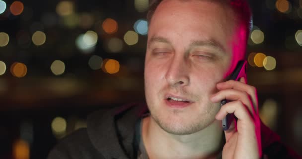 夜に携帯電話で話してる若い男 — ストック動画
