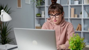 Gözlüklü kadın dizüstü bilgisayarda çalışıyor. 