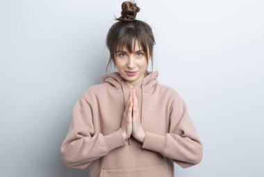 Gri arka planda poz veren uzun saçlı güzel bir kadın..