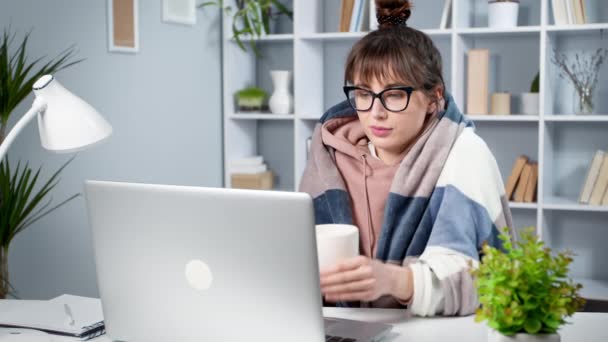遊んだお茶を飲みながらノートパソコンで勉強する女子大生 冷たい作品を持つ若い女性のフリーランスは コンピュータを使用しています — ストック動画