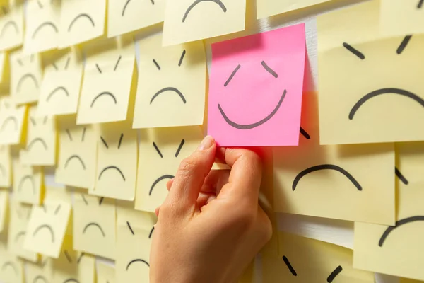 The concept of a successful business idea drawn on a paper stickers. Smile and happiness on the background of sad notes.