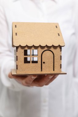 Bir emlakçının elinde bir model ev.