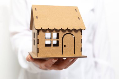 Bir emlakçının elinde bir model ev.