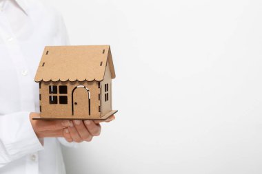 Bir emlakçının elinde bir model ev..