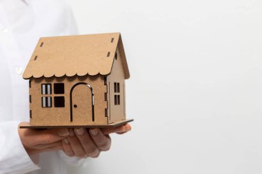 Bir emlakçının elinde bir model ev..