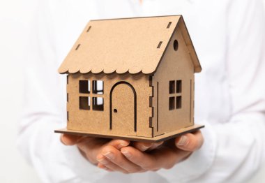 Bir emlakçının elinde bir model ev..