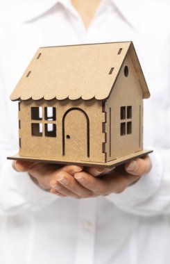 Bir emlakçının elinde bir model ev..