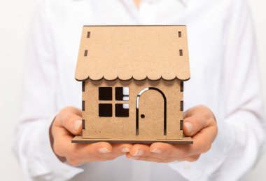 Bir emlakçının elinde bir model ev..