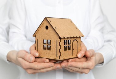 Model ev bir ailenin, bir erkeğin ve bir kadının elinde. Konut kredisi veya gayrimenkul satın alma kavramı.