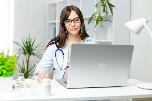 Terapeuta Femenina Trabajando Distancia Sentada Portátil Con Auriculares Escribiendo Cuaderno —  Fotos de Stock