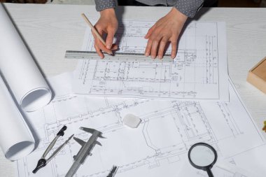 Mimar tasarımcı projenin bir taslağını beyaz kağıda çizer. Mühendislik planları..