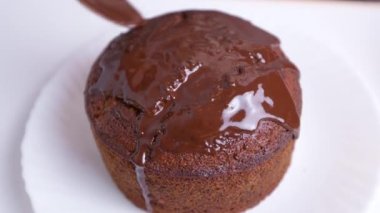 Kekin üzerine erimiş çikolata dökülüyor..