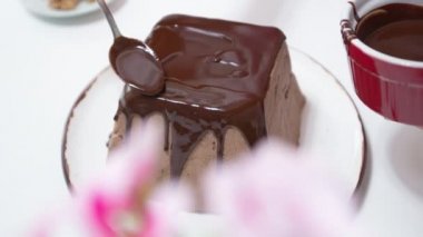 Pasta şefi tatlıya çikolata kreması sürüyor. Vejetaryen keki.