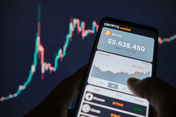 Mobil uygulama şifreleme cüzdanlı akıllı telefon. Bir adam bitcoin 'in fiyat tablosunu mobil bir uygulamada analiz eder. Kripto para ticareti kavramı 