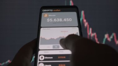  Mobil uygulama şifreleme cüzdanlı akıllı telefon. Bir adam bitcoin 'in fiyat tablosunu mobil bir uygulamada analiz eder. Kripto para ticareti kavramı