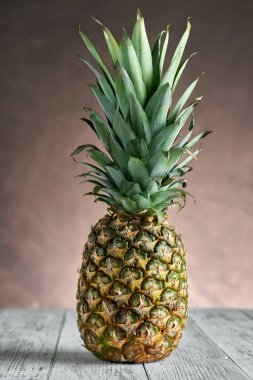 Tahta bir masada tam ananas. Tatlı, ekşi ve sulu bir tat. Bol miktarda lif, C vitamini ve mineral. Yiyecek, meyve ya da sağlık sigortası konsepti..