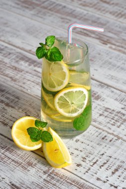 Bardakta soğuk limonata ve eski ahşap bir masada meyve. Yaz ferahlatıcı içecek. Limon ve nane ile detoksifikasyon için soğuk su 