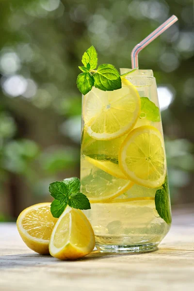 Bardakta soğuk limonata ve eski ahşap bir masada meyve. Yaz ferahlatıcı içecek. Limon ve nane ile detoksifikasyon için soğuk su 