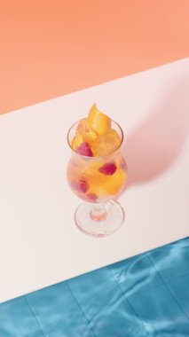 VERTICAL VIDEO parlak turuncu kokteyl ahududu ve buz küpleri havuz kenarında. Tazeleyici içecek. Sıcak bir yaz gününde hafif içkiler. Yazın plaj partisi.
