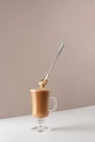 Kapuçino, köpük ve kaşık kokulu cam bardak. Kapuçino, latte ya da sütlü kahve. Kafeler ve restoranlar için bir fincan kahve ile yaratıcı tasarım.. 