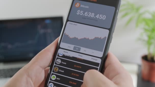 Bir Adam Akıllı Telefondan Popüler Kripto Para Birimlerinin Fiyatlarını Analiz — Stok video