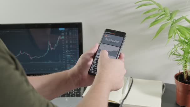 Mężczyzna Analizuje Rynek Kryptowalut Laptopie Kupuje Bitcoiny Pomocą Smartfona Smartfon — Wideo stockowe
