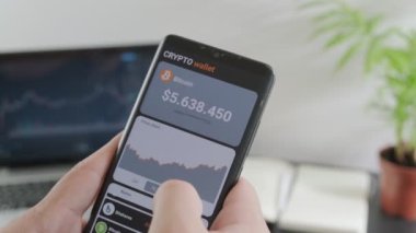 Adam bitcoin 'in fiyatını analiz ediyor ve akıllı telefonun mobil uygulamasından bitcoin alıyor. Mobil uygulama cüzdanı şifreli akıllı telefon. Kripto para ticareti kavramı