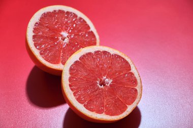 Kırmızı zemin üzerinde taze sulu greyfurt. Taze yaz meyveleri.. 