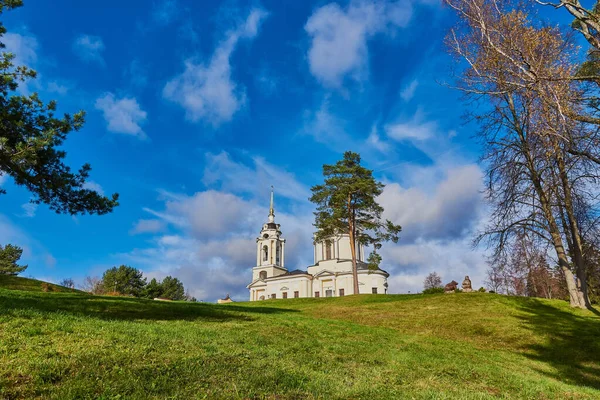 Hermosa iglesia en una colina verde contra un cielo. — Foto de Stock