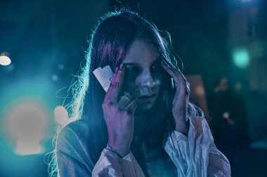 Cadılar Bayramı için makyajlı genç kız mavi neon ışıkta.