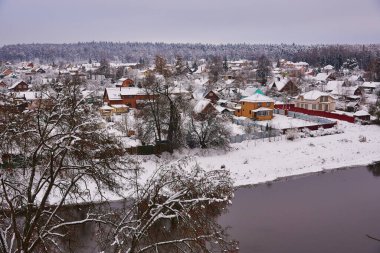 Kış kırsal arazisi. Nehir kıyısında karla kaplı bir köy..