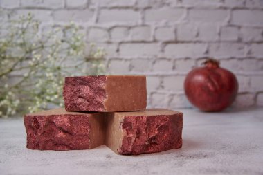 Tuğla duvara karşı gri bir tezgahın üzerinde parlak el yapımı sabun ve taştan bir ağ. Güzel bir el yapımı hobi çevresel ürünlerden doğal sabun..