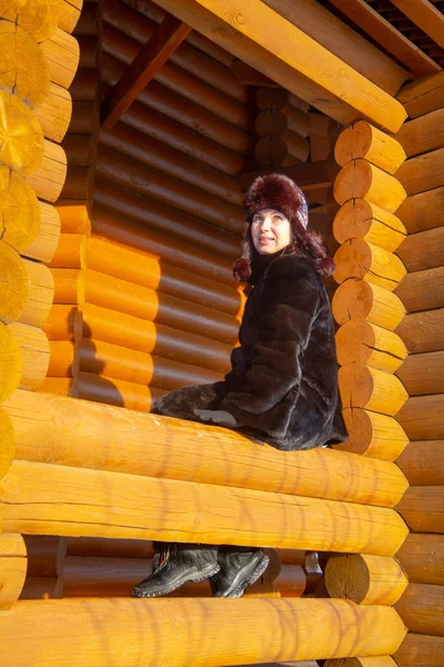 Middle Aged Woman Fur Hat Looks Out Window Log House — Stock Photo, Image