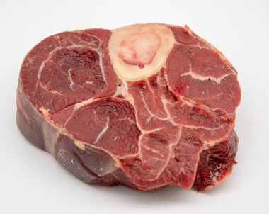 Beyaz arka planda kemik olan bir parça çiğ et..