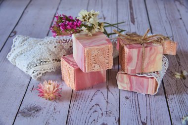 Gri arka planda pembe desenli el yapımı sabun. Kişisel hijyen malzemeleri, sağlıklı yaşam tarzı..