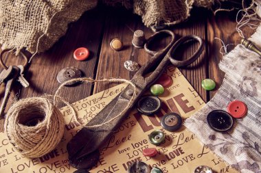 Ahşap arka planda terzi kadın için iplik makas düğmeleri dikiyorum. Vintage Arkaplanı.