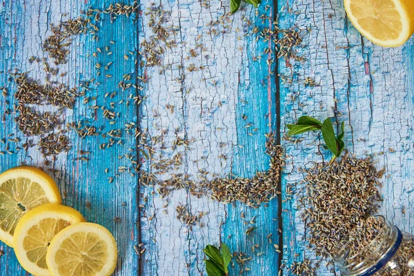 Dried lavender flowers, lemon slices and mint leaves on a blue wooden background. — Stock Photo, Image